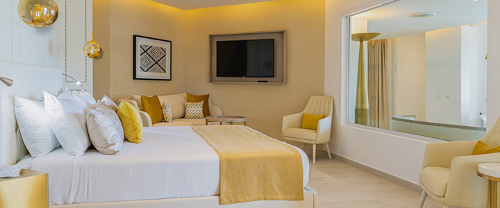 Stilvoll eingerichtetes Doppelzeimmer, in zarten Gelbtönen gehalten, im Grand Bavaro Princess.